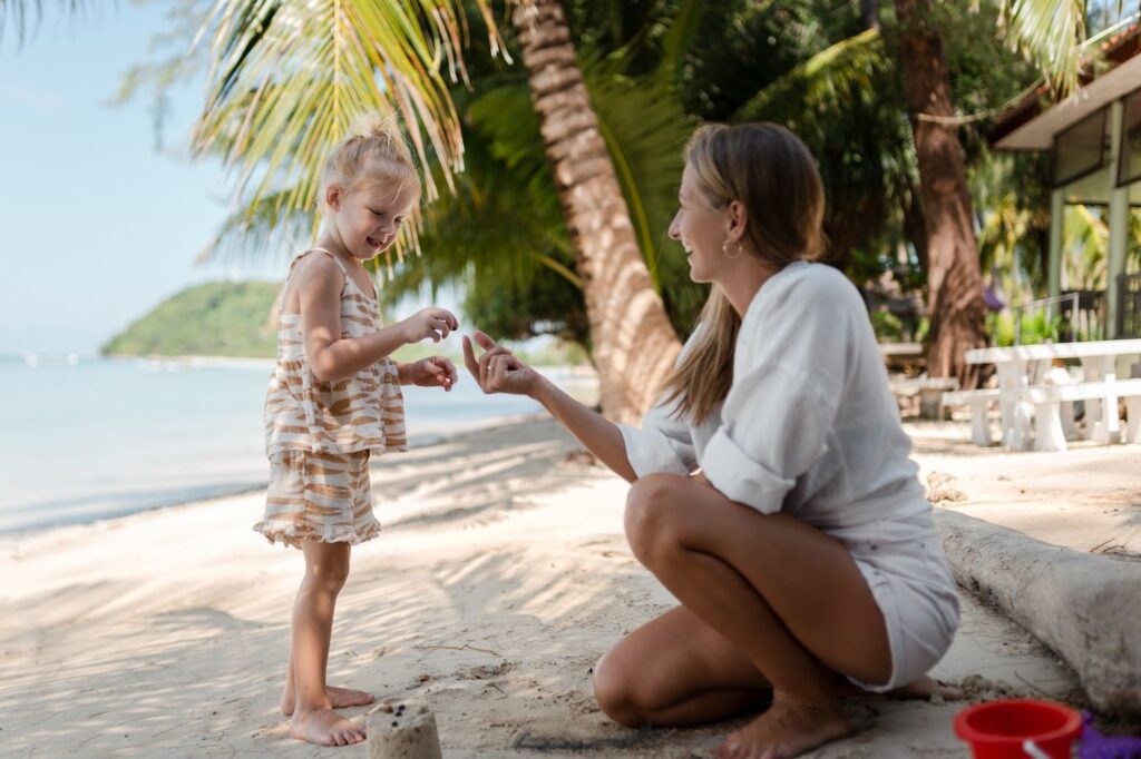 Mother and kid playing on a beach, enjoying one of the relaxing things to do in Oahu with kids.