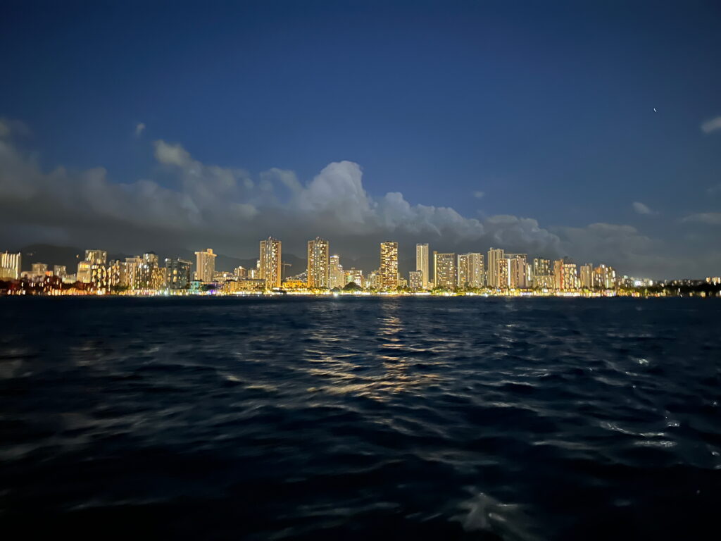 Sunset cruise in Waikiki with ocean view and golden sunset sky.