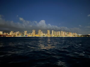 Sunset cruise in Waikiki with ocean view and golden sunset sky.